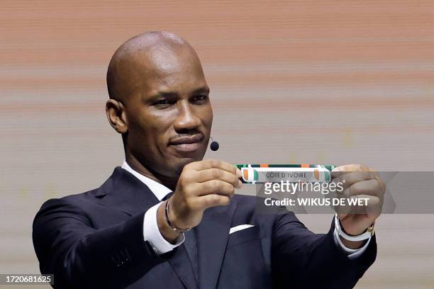 Former Ivorian footballer Didier Drogba shows the paper slip of Ivory Coast during the Africa Cup of Nations 2024 official draw at Parc des...