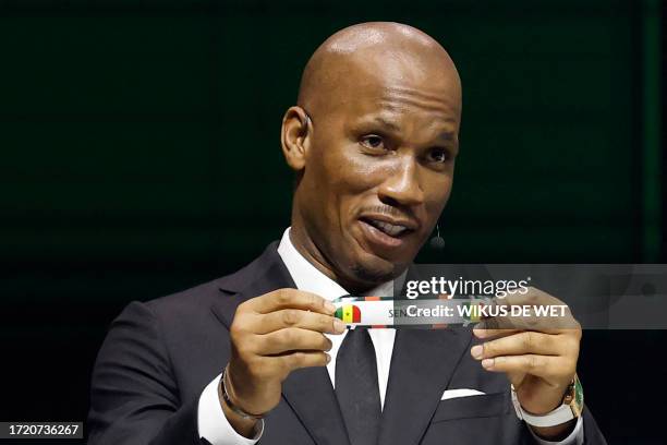 Former Ivorian footballer Didier Drogba shows the paper slip of Senegal during the Africa Cup of Nations 2024 official draw at Parc des Expositions...