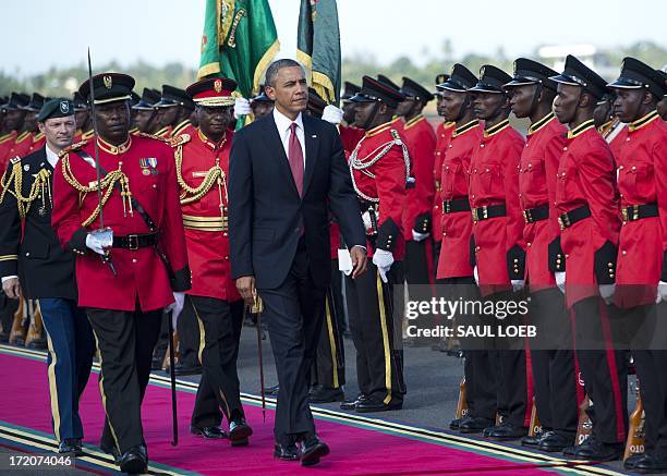 President Barack Obama walks past an honour guard upon arrival on Air Force One at Julius Nyerere International Airport in Dar Es Salaam, on July 1,...