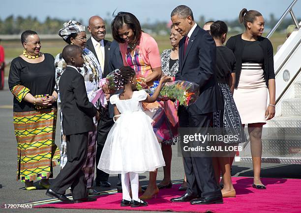 Boy and a girl present flowers to US President Barack Obama and First Lady Michelle Obama upon arrival of Air Force One at Julius Nyerere...