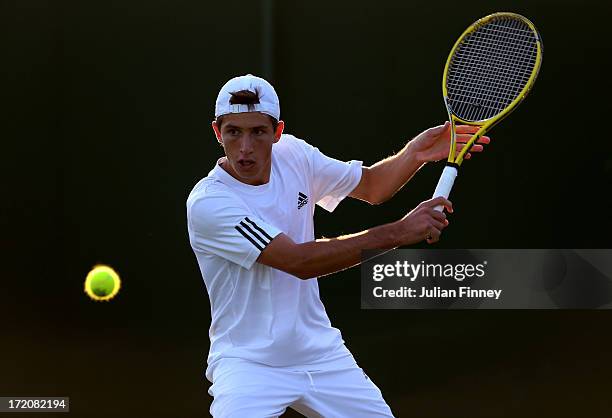 Pedro Cachin of Argentina plays a backhand during the Boys' Singles first round match against Mazen Osama of Egypt on day seven of the Wimbledon Lawn...