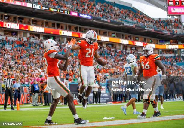 Miami Hurricanes running back Henry Parrish Jr. Celebrate with teammates after scoring a touchdown during the second quarter of an ACC conference...