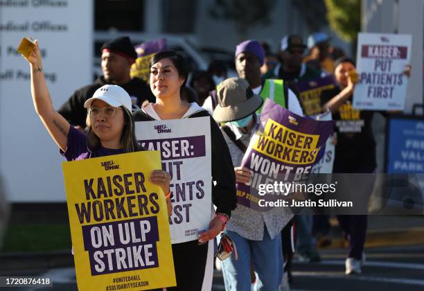 Striking Kaiser Permanente workers hold signs as they march in front of the Kaiser Permanente Vallejo Medical Center on October 06, 2023 in Vallejo,...