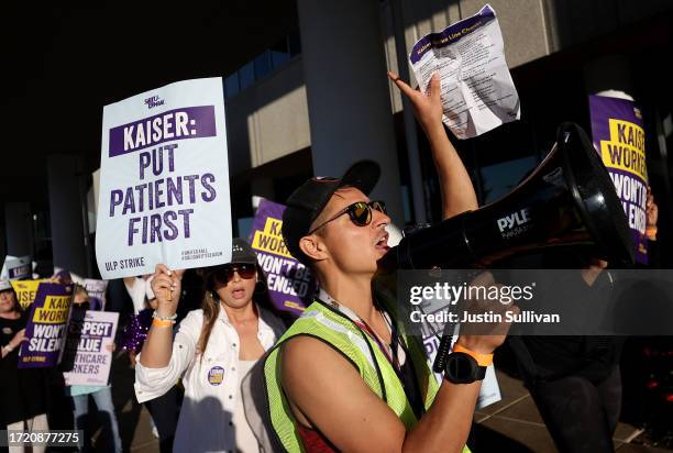 Striking Kaiser Permanente workers hold signs as they march in front of the Kaiser Permanente Vallejo Medical Center on October 06, 2023 in Vallejo,...