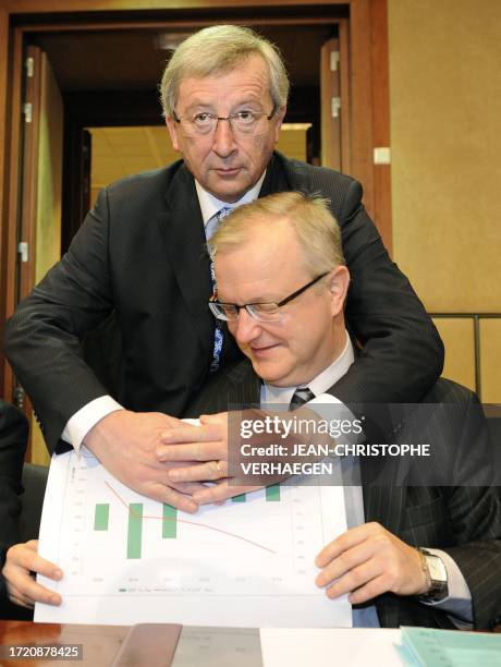 Eurogroup president and Luxembourg Prime Minister Jean-Claude Juncker jokes and hides a chart about Greece's reducing deficit with European...