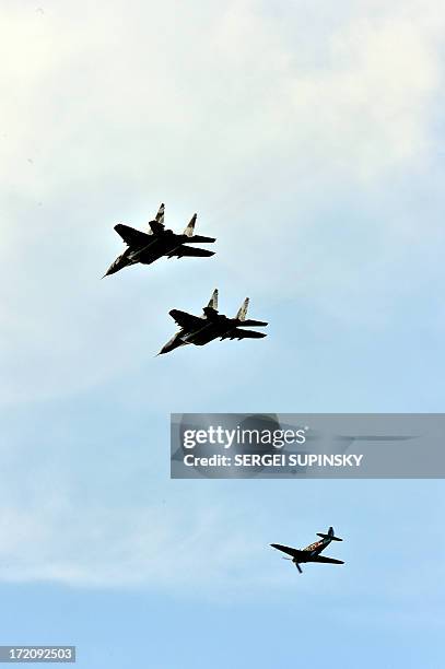 Two Ukrainian MIG-29 escort Soviet fighter Yak-3 with a British pilot above the Aviation Museum in Kiev, on July 1, 2013. 27 aircraft, one of the...