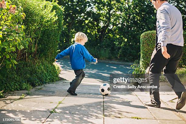 father and son playing football together - long sleeved stock pictures, royalty-free photos & images