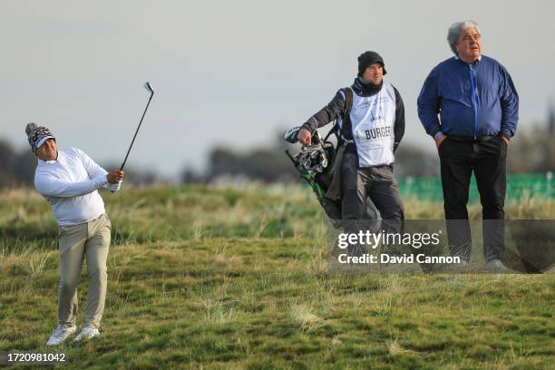 Hennie Du Plessis of South Africa plays his second shot on the second hole watched by his amateur partner Schalk Burger during Day Two of the Alfred...