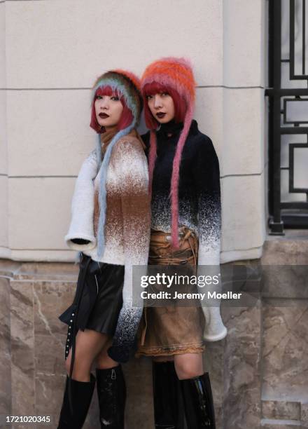 Twins Ami & Aya Amiaya were seen wearing black boots, a black and brown skirt, colorful hats and white and brown as well as white and black striped...