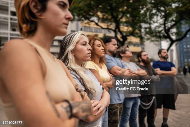 people with arms crossed during a protest outdoors - activist stockfoto's en -beelden