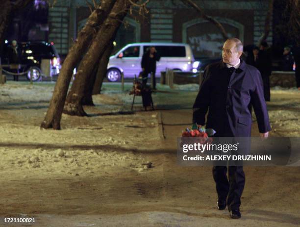 Russian Prime Minister Vladimir Putin walks to lay flowers outside the burnt-out Lame Horse nightclub in Perm early on December 8, 2009 in memory of...