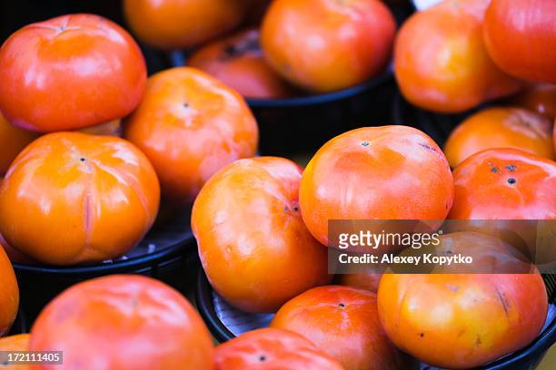 rare delicious persimmon at a street market - persimone stock-fotos und bilder