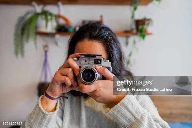 young woman using photo camera at home - digital camera stock pictures, royalty-free photos & images