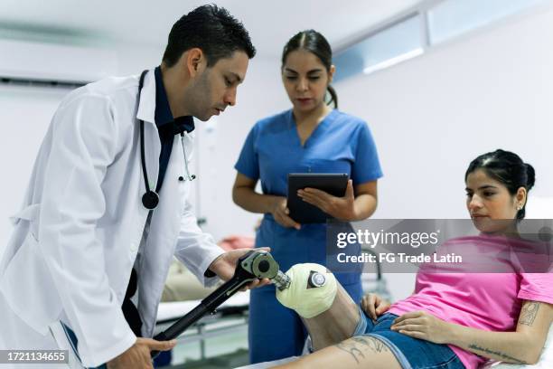 médecin examinant la prothèse d’un patient dans la salle d’examen de l’hôpital - blouse dexamen médical photos et images de collection