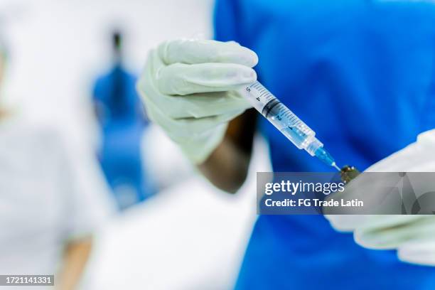 primo piano di un'infermiera che prepara il vaccino in ospedale - flu vaccine foto e immagini stock