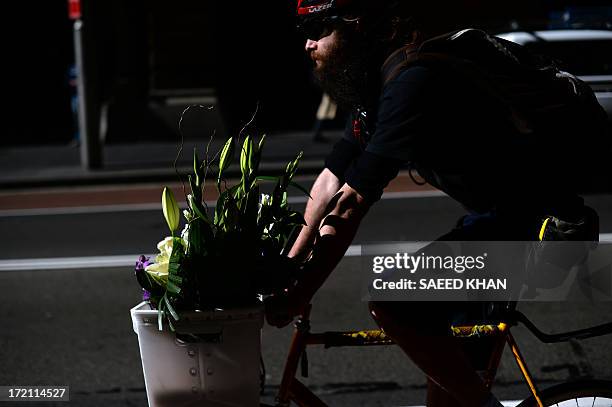 Messenger powers his bike to deliver a flower bouquet in the central business district of Sydney on July 2, 2013. Australia's central bank held the...