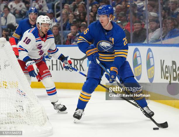 Rasmus Dahlin of the Buffalo Sabres skates with the puck as Artemi Panarin of the New York Rangers pursues during the first period at KeyBank Center...