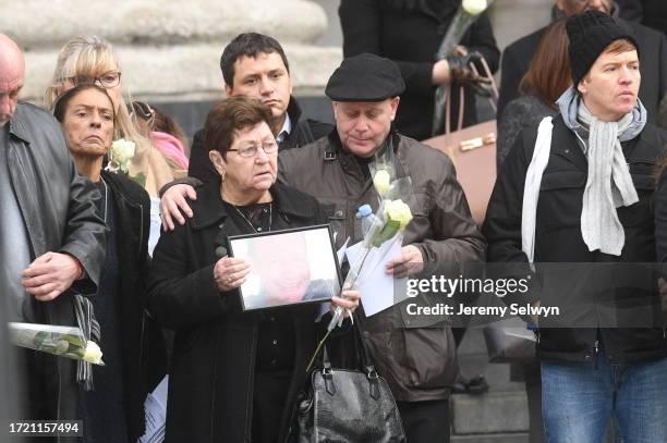 People Hold Photos And Flowers As They Leave After The Grenfell Tower National Memorial Service At St Paul'S Cathedral In London, To Mark The Six...