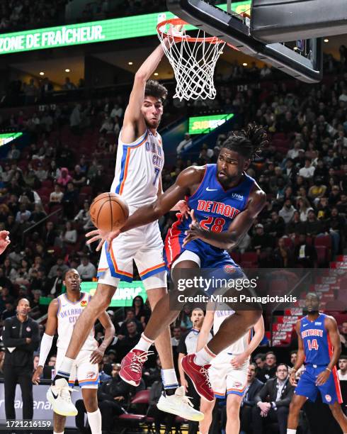 Isaiah Stewart of the Detroit Pistons plays the ball against Chet Holmgren of the Oklahoma City Thunder during the first half of a preseason NBA game...