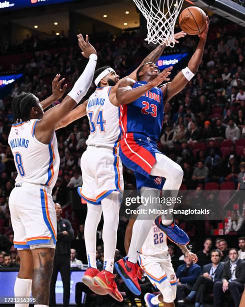 Jaden Ivey of the Detroit Pistons jumps with the ball towards the basket against Kenrich Williams of the Oklahoma City Thunder during the first half...