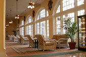 Hotel Lobby. Tropical setting. Rattan furniture, windows. Table,chairs.