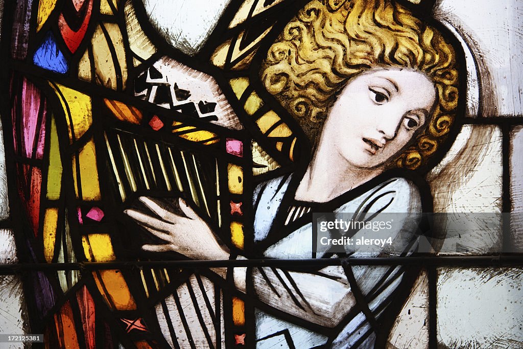 Stained glass window of angel playing the harp