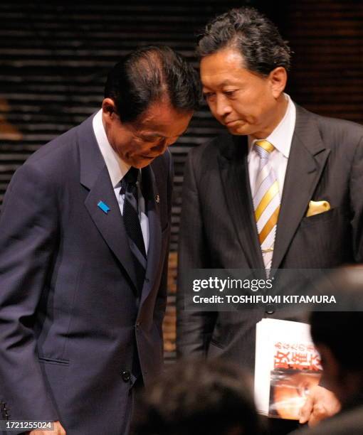 Japanese Prime Minister and ruling Liberal Democratic Party leader Taro Aso walks in front of opposition Democratic Party of Japan leader Yukio...