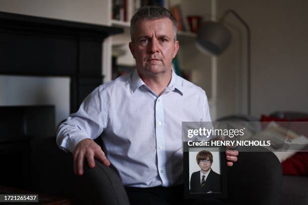 David Parfett poses with a picture of his late son Tom at his home in Maidenhead, United Kingdom, on September 22, 2023. At least a hundred victims...