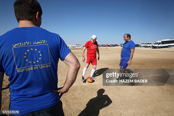 Player from the blue team, consisting of European diplomats, passes the ball to a player in the red team, consisting of Palestinians, during a...