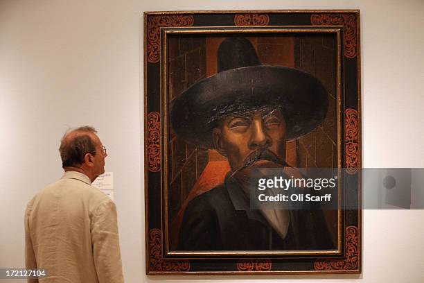 Man views a painting by David Alfaro Siqueiros entitled 'Zapata' in the Royal Academy of Arts on July 2, 2013 in London, England. The painting...