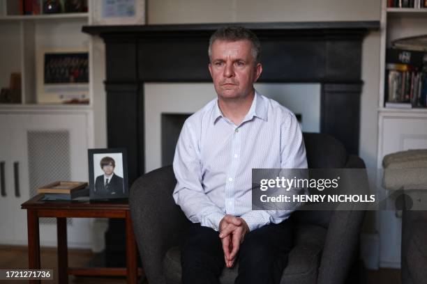 David Parfett sits next to a framed picture of his son Tom at his home in Maidenhead, United Kingdom, on September 22, 2023. At least a hundred...