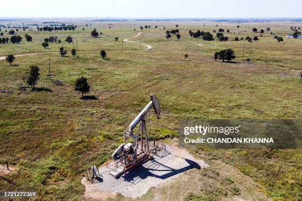 An aerial view shows a pumpjack operating at an oil well in Gray Horse, Oklahoma, on September 29, 2023. As eagles swoop overhead and a cool autumnal...
