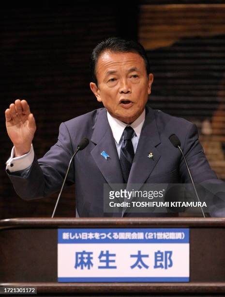 Japanese Prime Minister and ruling Liberal Democratic Party leader Taro Aso speaks to opposition Democratic Party of Japan leader Yukio Hatoyama...
