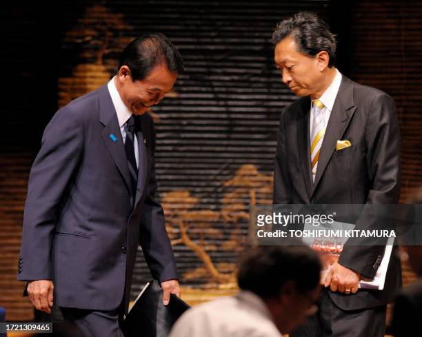 Japanese Prime Minister and ruling Liberal Democratic Party leader Taro Aso walks in front of opposition Democratic Party of Japan leader Yukio...