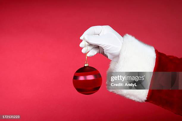 santa hands: holding red ornament - saint stockfoto's en -beelden