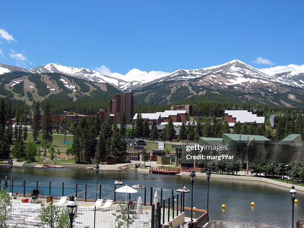 Lush summer resort facing snowy mountains in the distance