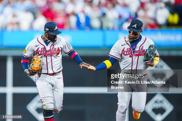 Michael Harris II of the Atlanta Braves is congratulated by Ronald Acuna Jr. #13 after making a diving catch and completing a double play to end the...