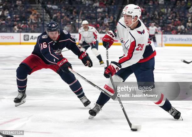 Hendrix Lapierre of the Washington Capitals shoots the puck while Brendan Gaunce of the Columbus Blue Jackets defends during the third period of the...