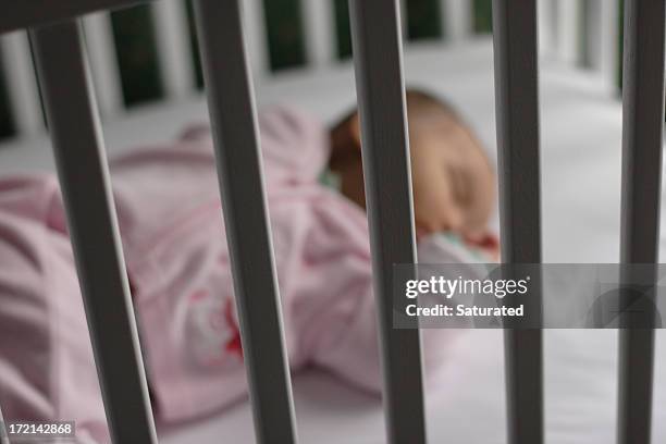 baby safely asleep in crib - baby crib stock pictures, royalty-free photos & images