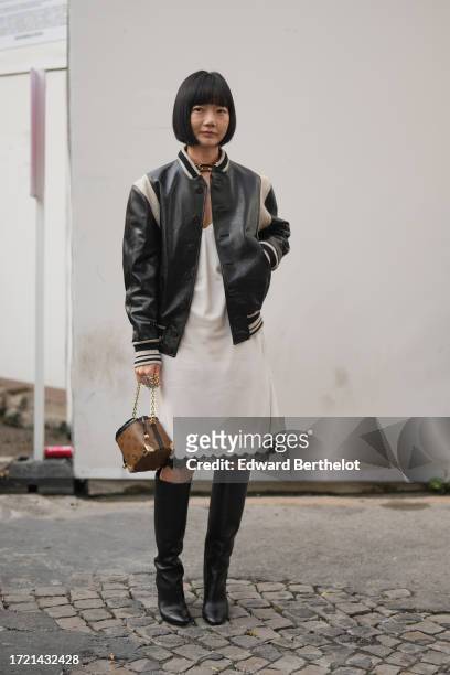 Bae Doona wears a black and white leather teddy jacket, a white knee long dress with lace borders, a brown monogram leather LV bag, knee high leather...