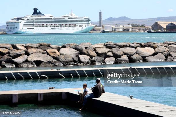 People fish near the Norwegian Spirit cruise ship, moored at Kahului Harbor in Maui during a tourism visit, on October 06, 2023 in Kahului, Hawaii....