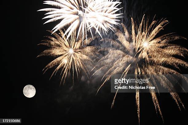 fireworks and a full moon on a dark sky - guy fawkes day stock pictures, royalty-free photos & images