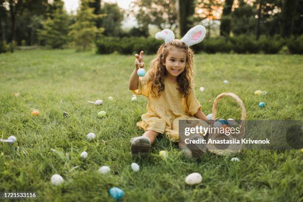 multi-ethnic girl searching for easter eggs. - eggs basket stock pictures, royalty-free photos & images