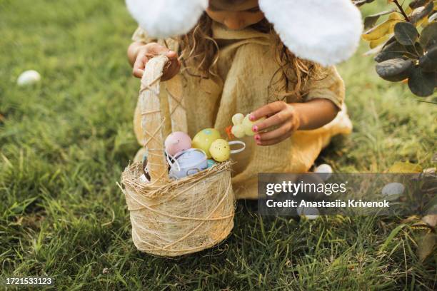 multi-ethnic girl searching for easter eggs. - easter egg hunt stock-fotos und bilder