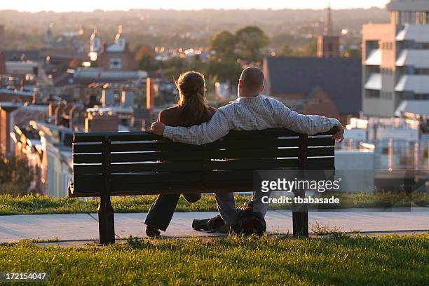jeune couple profitant d'un coucher de soleil - baltimore maryland photos et images de collection