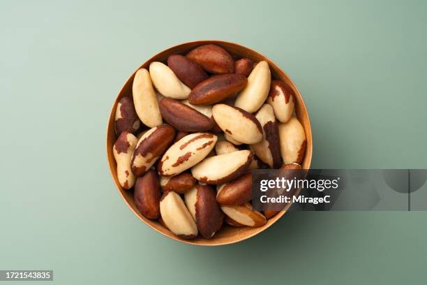 brazil nuts in wooden bowl on green background - castanha do pará - fotografias e filmes do acervo