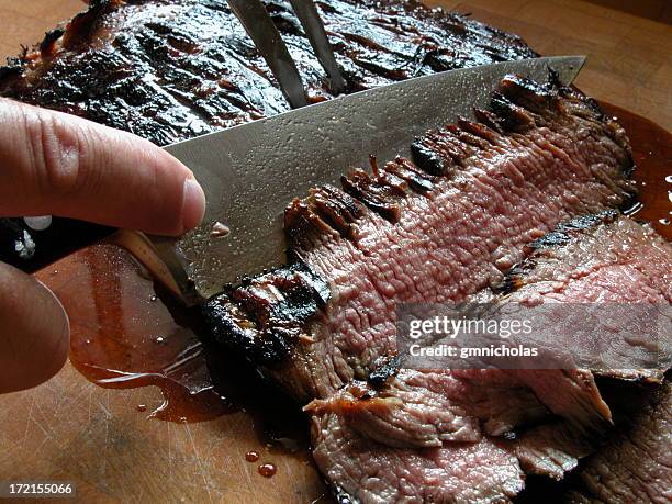 close-up of a knife carving a piece of grilled flank stake - carvery stockfoto's en -beelden