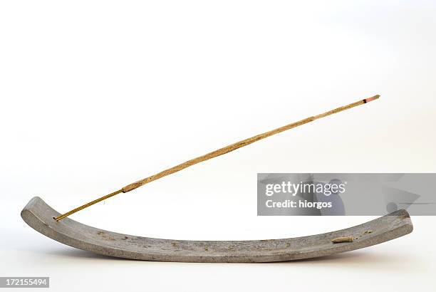 an incense stick burning on a curved plank - wierook gefabriceerd object stockfoto's en -beelden