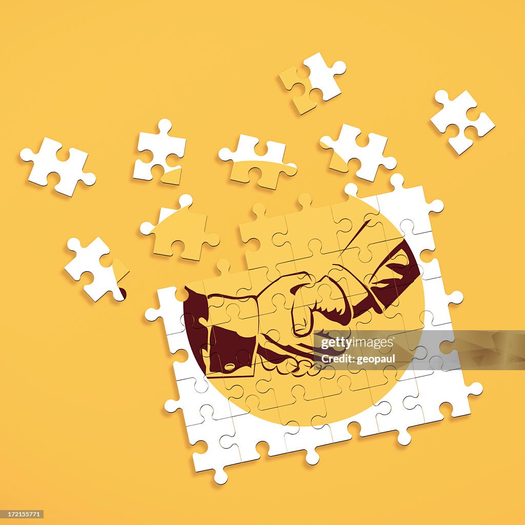 Puzzle pieces forming image of shaking hands