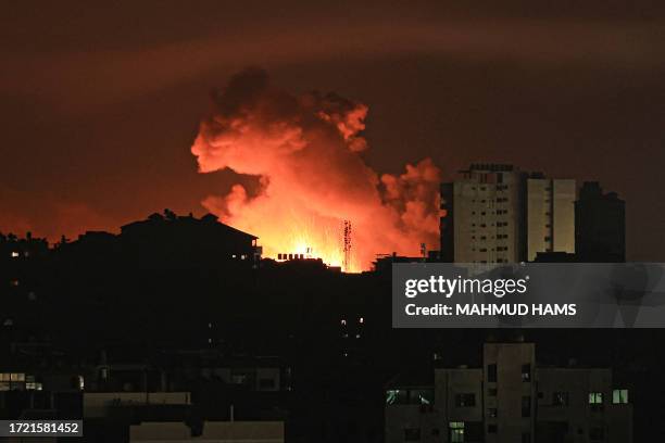 Fire and smoke rise above buildings in Gaza City during an Israeli air strike, on October 13 as raging battles between Israel and the Hamas movement...